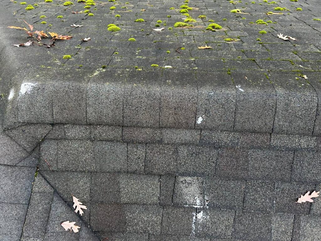 Worker on red shingle roof repair
